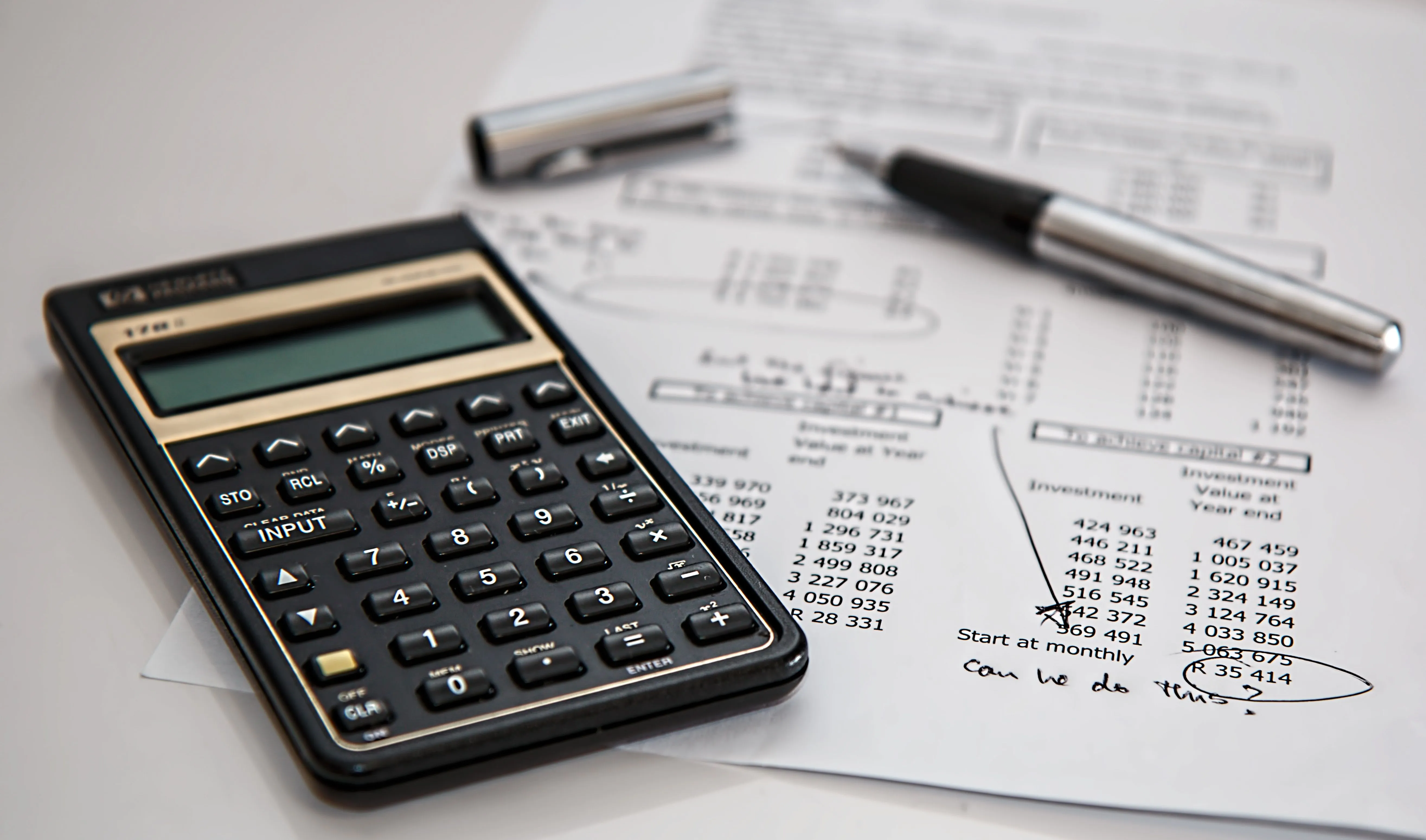 Calculadora e documentos financeiros sobre uma secretária