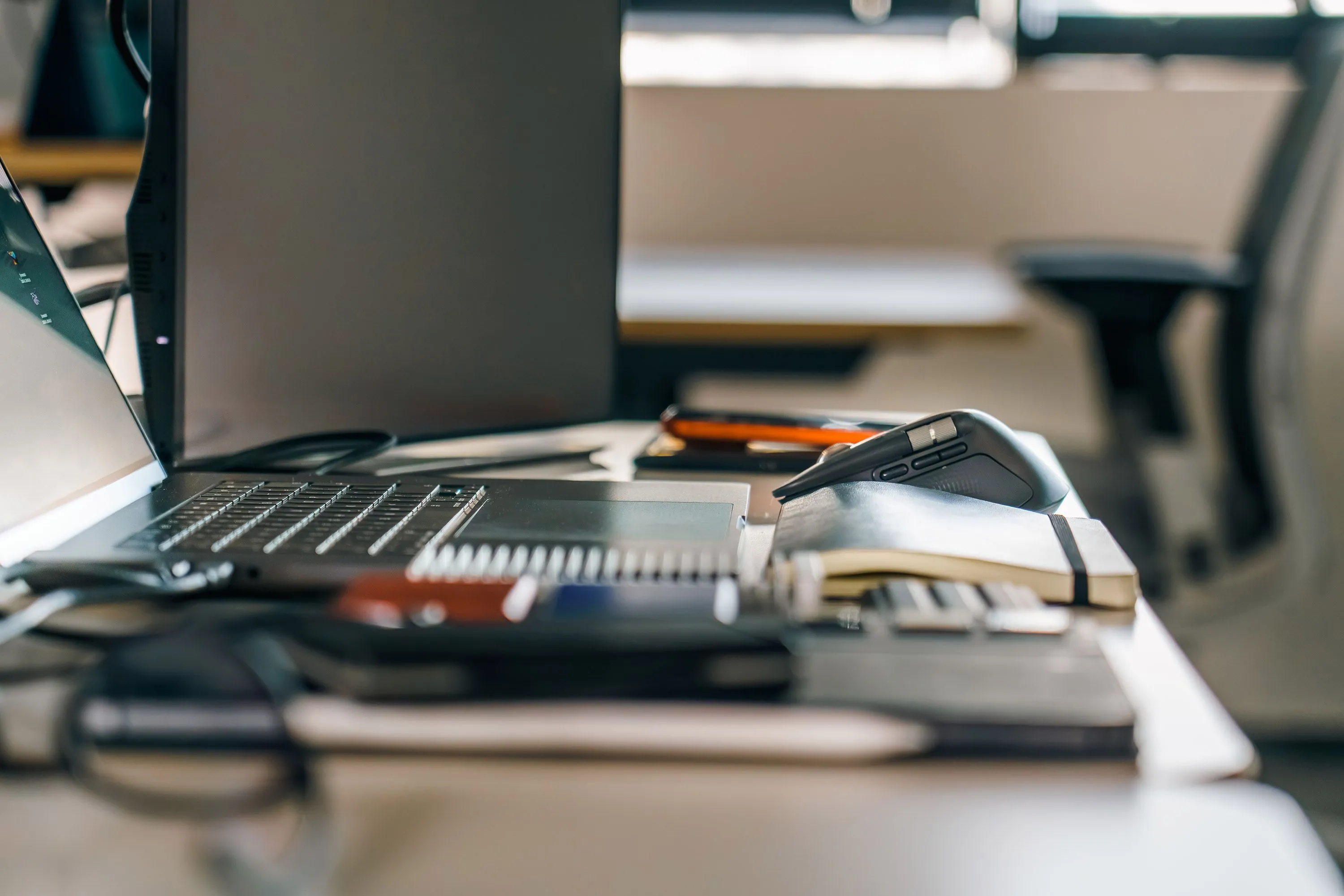 Secretária de escritório com computador portátil e caderno